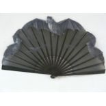 An early 20th century wooden and painted fan, the black organza hand painted with flying bats, the