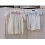 Child's dress with pink  smocking, a child's dress with blue smocking, another and a child's dress