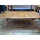 Ercol elm coffee table, rounded rectangular with rail under shelf, on turned tapering supports,