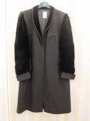 Nina Ricci Haute Boutique, Paris, a black wool coat with velvet shawl collar, faux fur sleeves