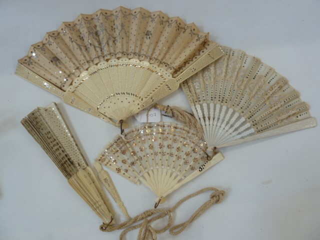 A pierced bone and silk fan, with silver sequinned decoration, the pierced sticks with silver