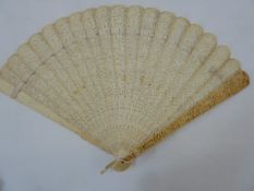 A 19th century Chinese export ivory brise fan, the guards with relief decoration of figures below