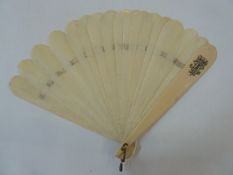 A late 19th century ivory brise fan, plain form with curved edges, the guards monogrammed with