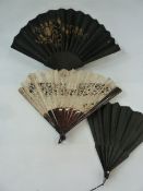 A tortoiseshell and lace fan, boxed 35.5cm, a black wooden fan, a black fan with black silk and gilt