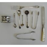 Silver napkin ring, a small silver tea fork, two silver sugar nips, miniature spoons and a mother-