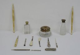 Silver lidded and glass dressing table bottle, a silver propelling pencil, a silver-handled manicure