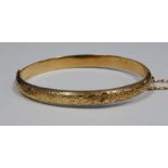 Early 19th century 9ct gold bangle, foliate engraved, cased, 3.6g approx (some damage)