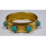 Victorian gold coloured metal hinged bangle having raised turquoise set circular balls within