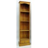 Modern narrow pine bookcase with drawer under, raised on plinth, 45cm x 180cm