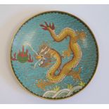 Chinese cloisonne saucer, decorated with a dragon chasing a flaming pearl, reserved on a blue