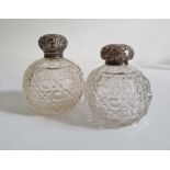 Pair of early 20th century silver lidded and glass circular cut glass scent bottles, the silver