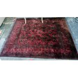 Red ground rug with foliate design, stepped border, 190cm x 135cm approx