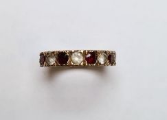 Gold-coloured metal, diamond and garnet eternity ring
