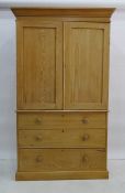 19th century pine linen-press, moulded cornice above two panelled doors enclosing shelves on base of