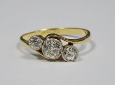 18ct gold and diamond three-stone ring, the central circular bezel-set diamond 0.4ct approx, flanked