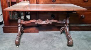 Walnut rectangular topped coffee table on carved end support united by stretcher, brass castors,