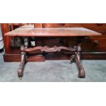 Walnut rectangular topped coffee table on carved end support united by stretcher, brass castors,