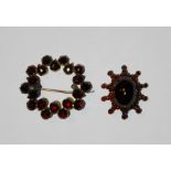 Cabochon garnet set star shaped brooch and another garnet circular brooch (2)