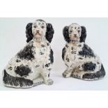 Pair of pottery Staffordshire-type model spaniels in black and white, 35cm high (2)