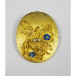 Victorian gold-coloured oval brooch/pendant with relief of bird and nest, with enamelled flowers and