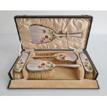 1930's silver and enamel mounted dressing set comprising of four brushes and mirror, cased, the pale