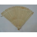 A 19th century bone fan, shallow relief, decorated with oval motif initials MV (?) , flanked by