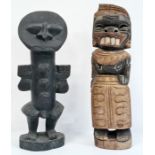 Carved African figure, possibly West African, standing with arms raised and another carved female