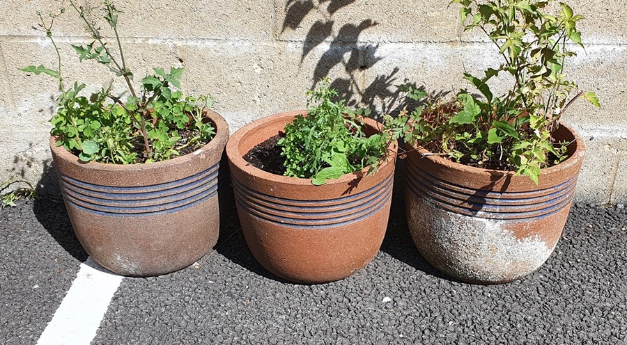 Three terracotta planters with blue incised decoration, approx 38cm diameter