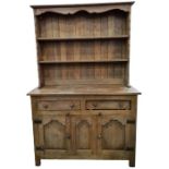 20th century oak dresser, with open shelves above two drawers and three cupboard doors, raised on