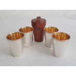 Set of four silver shooting / travelling / hunting cups with gilt wash interiors in a fitted brown