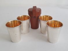 Set of four silver shooting / travelling / hunting cups with gilt wash interiors in a fitted brown