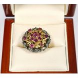 Silver-gilt and ruby cluster ring set seven stones in flowerhead pattern to centre, with surround of