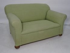 Early 20th century two seater sofa in green upholstery, turned bun feet