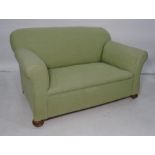 Early 20th century two seater sofa in green upholstery, turned bun feet