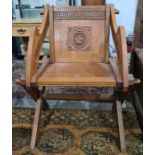 Reproduction oak Glastonbury type chair with carved decoration