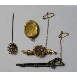 Victorian gold brooch decorated with harp and clovers (marks worn), a gold-coloured locket, a gold