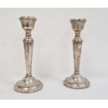 A pair of 20th Century silver mounted candlesticks, tapering on circular bases, 19cm high
