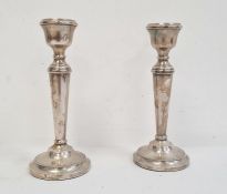 A pair of 20th Century silver mounted candlesticks, tapering on circular bases, 19cm high