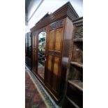 Late 19th century mahogany three section wardrobe, ogee moulded pediment, with central glazed door