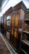Late 19th century mahogany three section wardrobe, ogee moulded pediment, with central glazed door