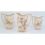 Three Crown Ducal 'Bisque ware' graduating jugs, bird and butterfly design, the largest 21cm high (