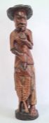 Carved wooden fisherman figure in a black hat, holding catch, 84cm high