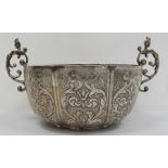 A silver coloured two-handled bowl, hammered and engraved decoration of birds and scrolls, female