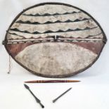 An African shield, elliptical shaped painted with white ground with black and dark red lines, two
