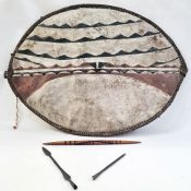 An African shield, elliptical shaped painted with white ground with black and dark red lines, two