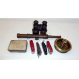 A pair of binoculars, assorted penknives, extending telescope, brass candlestick and a tin (one