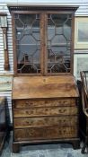 Early 19th century mahogany bureau bookcase, the dentil cornice above pair astragal-glazed folding