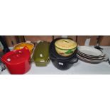 Various Le Creuset and other cast iron casseroles in orange, red, green and black, five graduated
