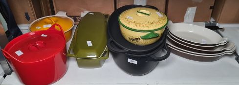 Various Le Creuset and other cast iron casseroles in orange, red, green and black, five graduated