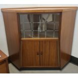 Mid-century corner unit with two sliding glass doors above two cupboard doors, plinth base